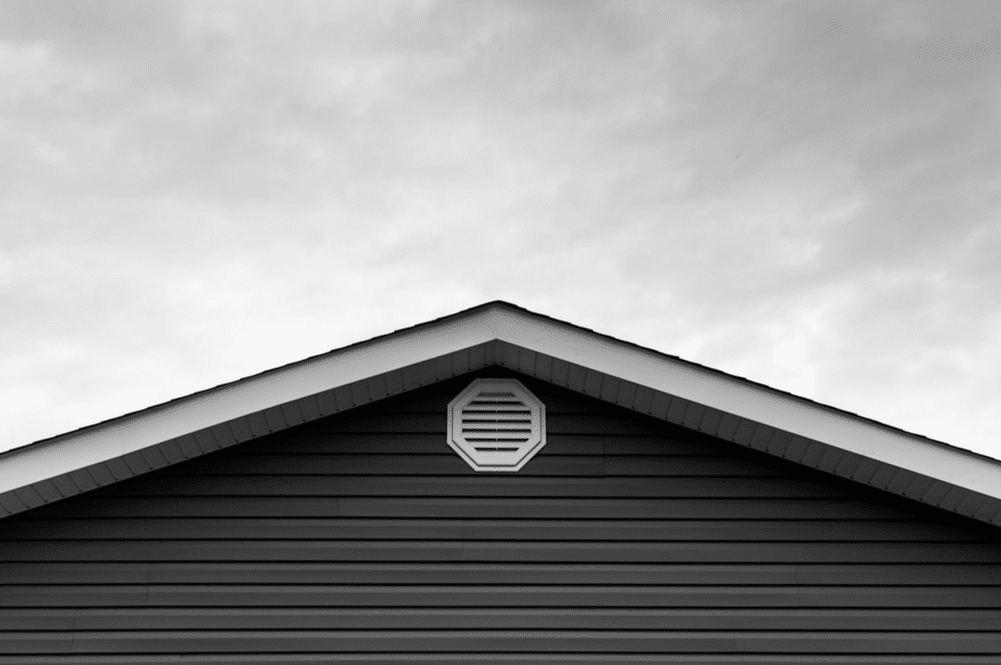 Grey gable roof in front of a cloudy sky