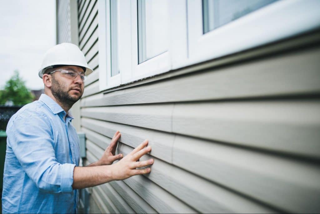 man-inspecting-siding