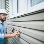 man-inspecting-siding