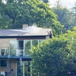 man-pressure-washing-his-shingled-roof