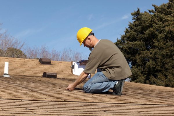 roofer-in-hard-hat-conducting-roof-inspection-of-Charlotte-residential-roof